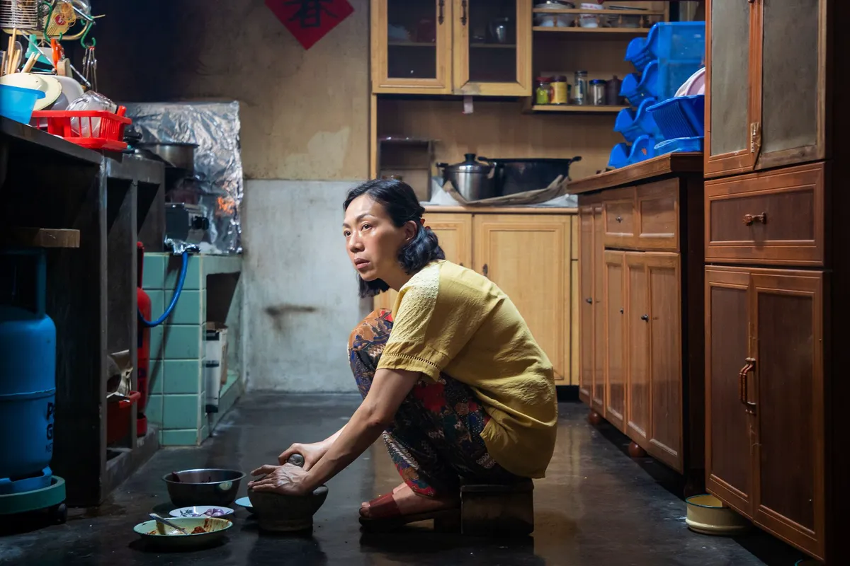 由萬芳飾演的阿英蹲身下廚。