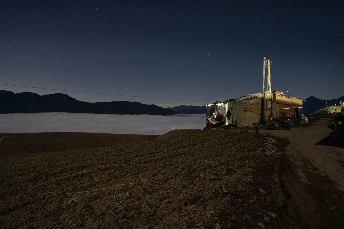 華南雲雨帶通過後，海拔2400公尺的山區出現美麗雲海，持續到晚間仍未散去，但是山上氣溫低，加上在田裡工作一天後，他們寧可待在工寮內避寒。